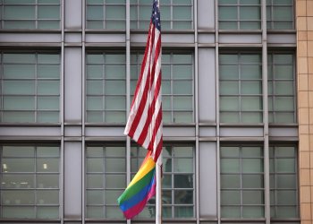 The rainbow flag flies under the US flag at the entrance to the US embassy in Moscow in June 2021 / ©AFP