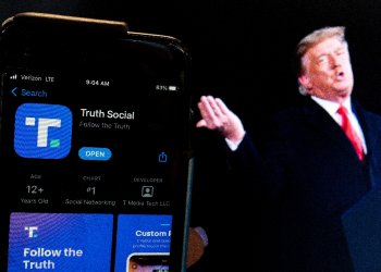 Donald Trump next to a phone screen displaying the Truth Social app / ©AFP