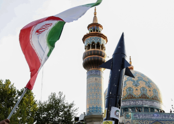 Iranians lift up a flag and the mock up of a missile during a celebration following Iran's missiles and drones attack on Israel, on April 15 2024, at Palestine square in central Tehran / ©AFP