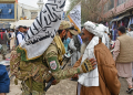 A Taliban security personnel greets a Muslim devotee after Eid al-Fitr prayers in the city of Pul-e-Khumri in April 2024 / ©AFP