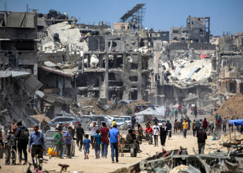 People move past destroyed buildings in Khan Yunis in the southern Gaza Strip  / ©AFP