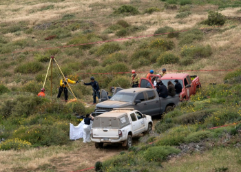 Rescuers are seen working at a clifftop shaft where bodies believed to be those of three missing surfers were discovered. ©AFP